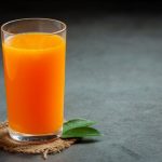 suco-de-laranja-fresco-no-copo-em-fundo-escuro_1150-45557