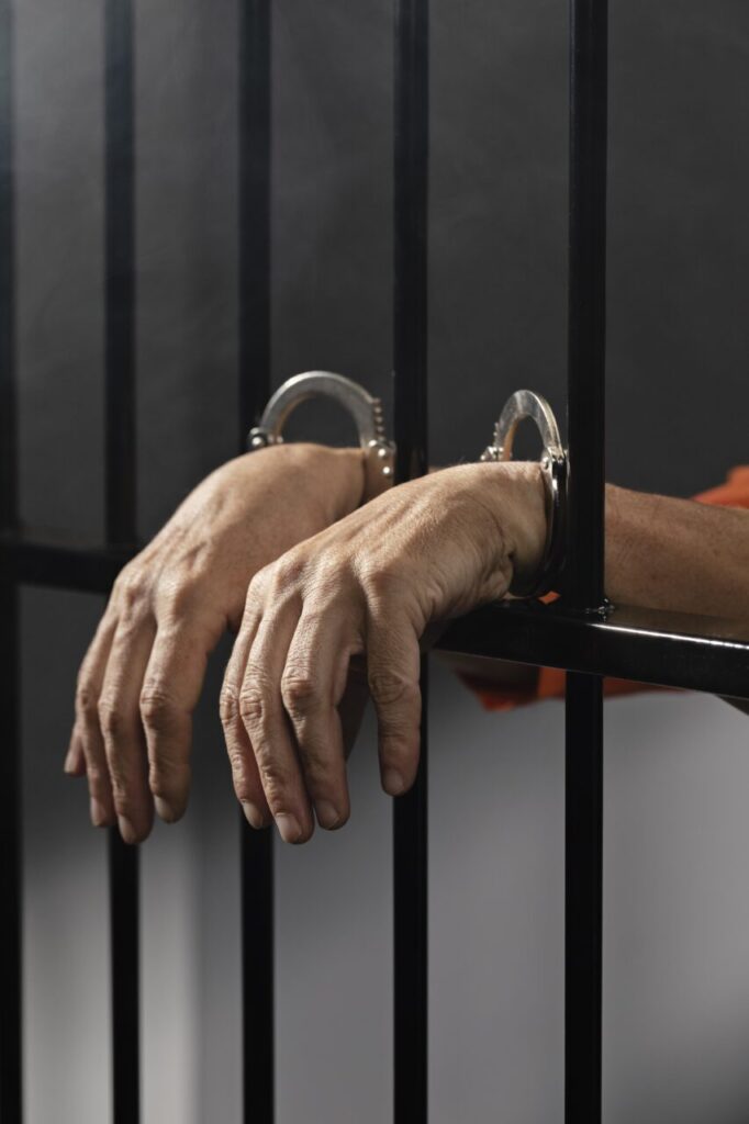 close-up-hand-wearing-cuffs-jail
