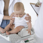 adult-taking-care-baby-weight