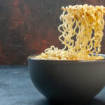 bottom-view-chopsticks-asian-ramen-noodles-bowl-dark-table-waribashi
