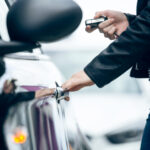 Beautiful young woman opening her car.