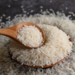 arroz-moido-em-uma-tigela-e-uma-colher-de-pau-no-chao-de-cimento-preto_1150-20058