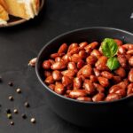 close-de-uma-xicara-com-feijao-vermelho-cozido-decorado-com-folhas-de-manjericao_166373-805