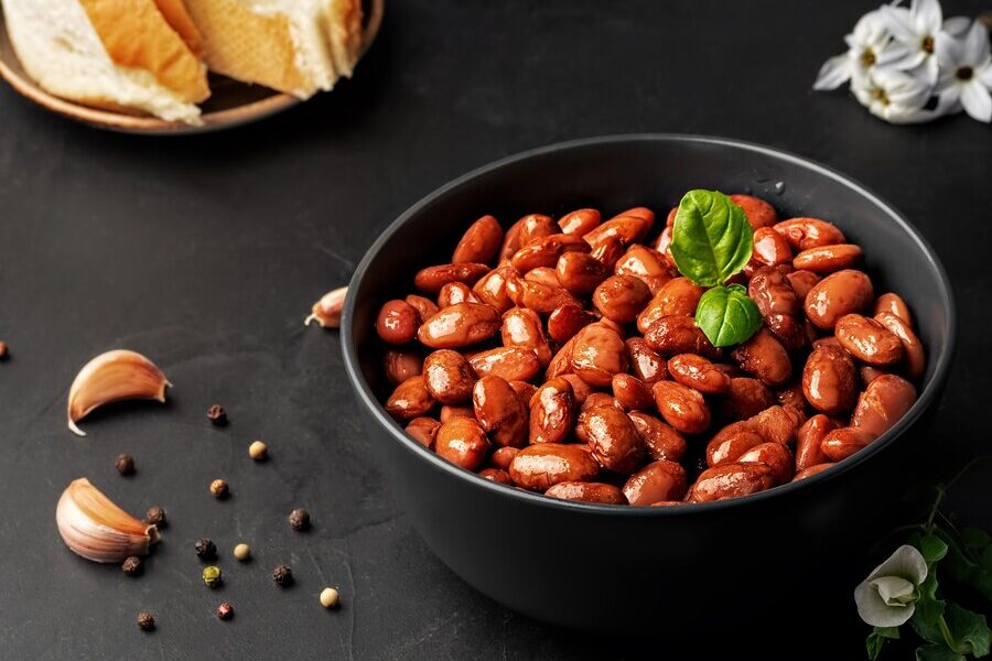 close-de-uma-xicara-com-feijao-vermelho-cozido-decorado-com-folhas-de-manjericao_166373-805