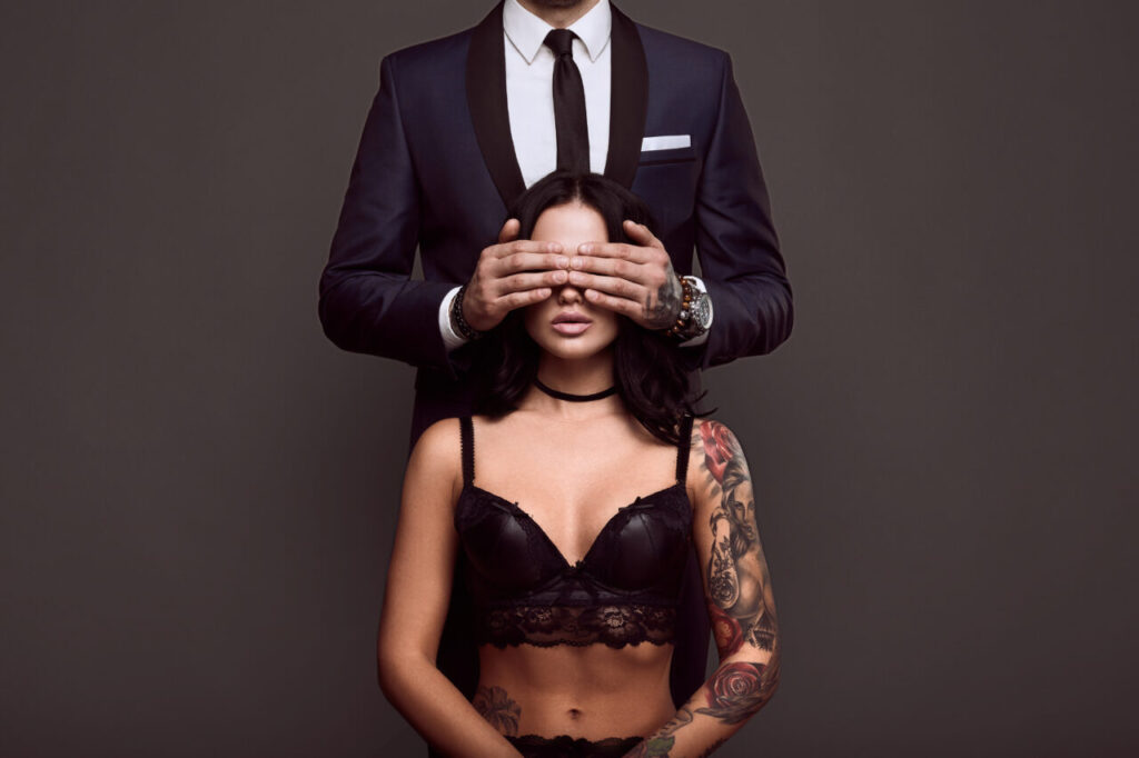 Portrait of a brutal man in suit and sexy girl