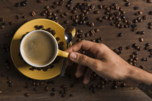 passe-segurar-copo-com-cafe-perto-prato